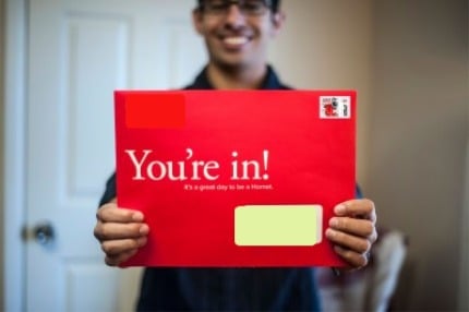 Student holding You're In envelope