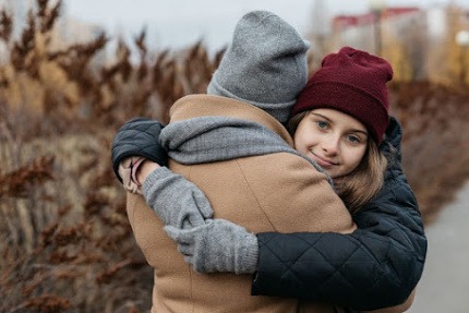 Mom and tenn daughter hugging