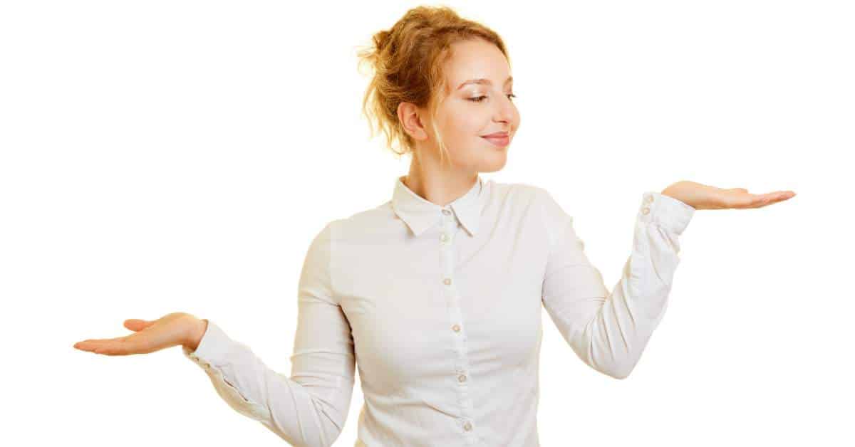 A woman holding up both her hands as if weighing her options