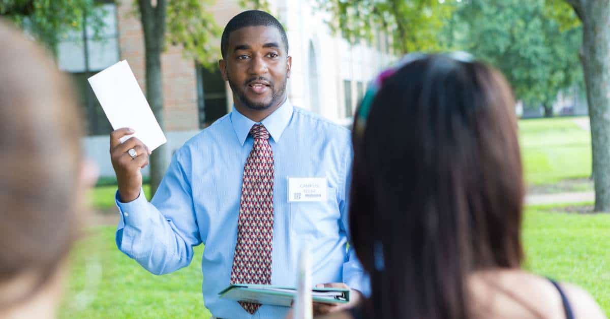 Young man giving a campus tour to potential students