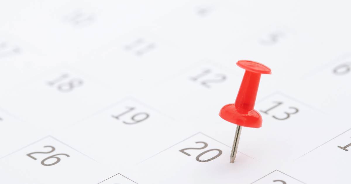 Photo of a calendar with a red push pin on the 20th.