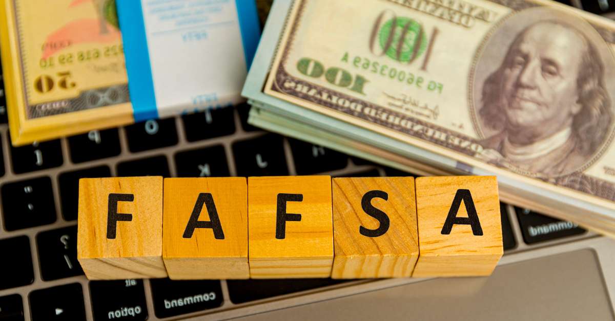 Money and blocks spelling out "FAFSA" sitting on a keyboard