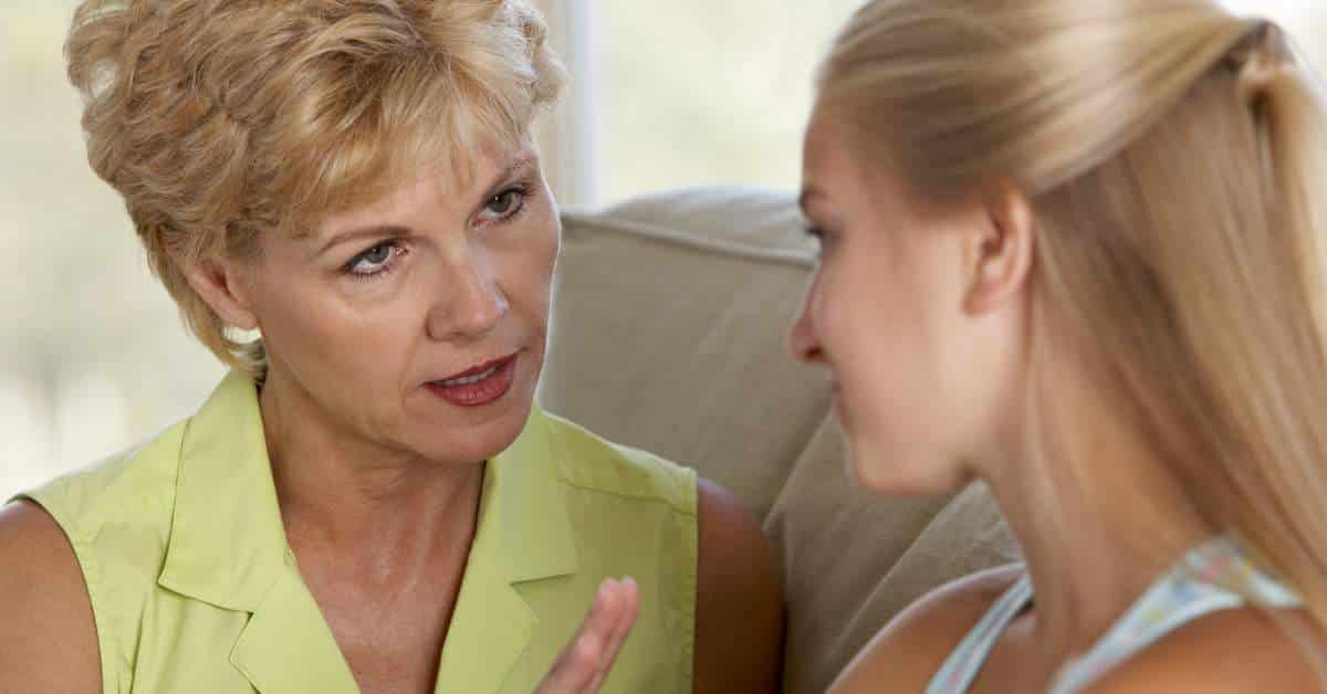 Mother facing her daughter and having a serious conversation