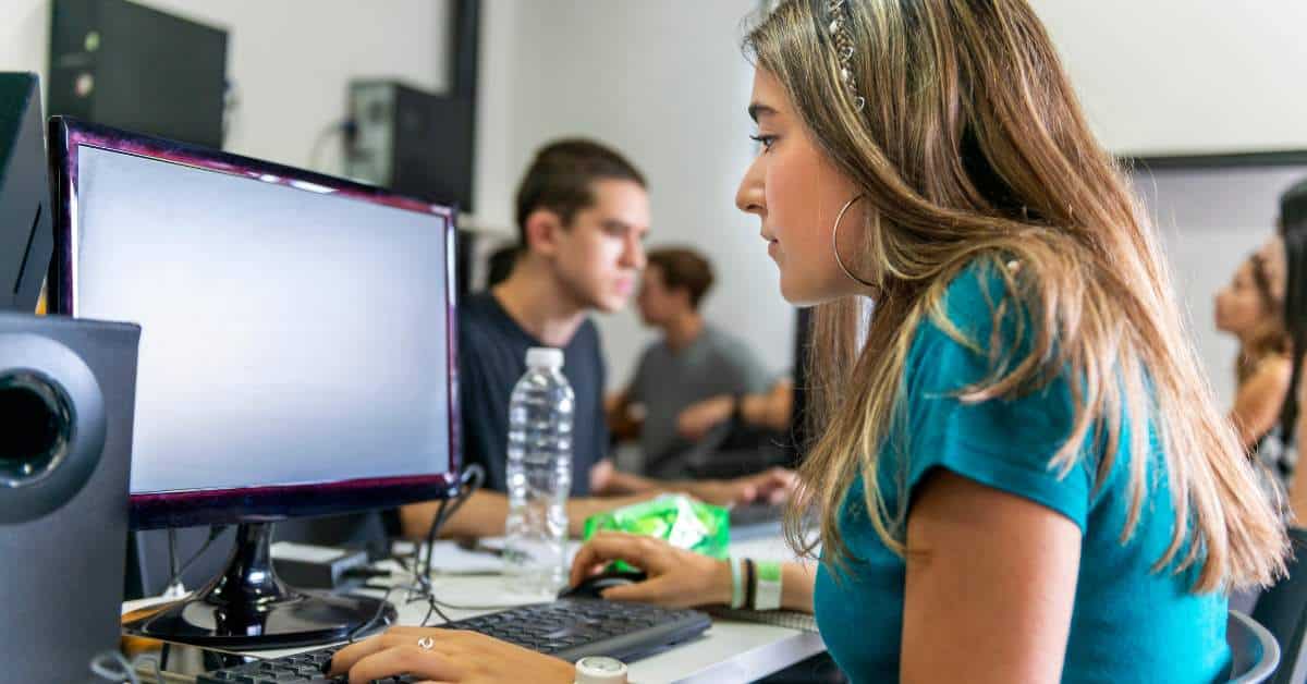 Young woman sitting and working in front of a computer