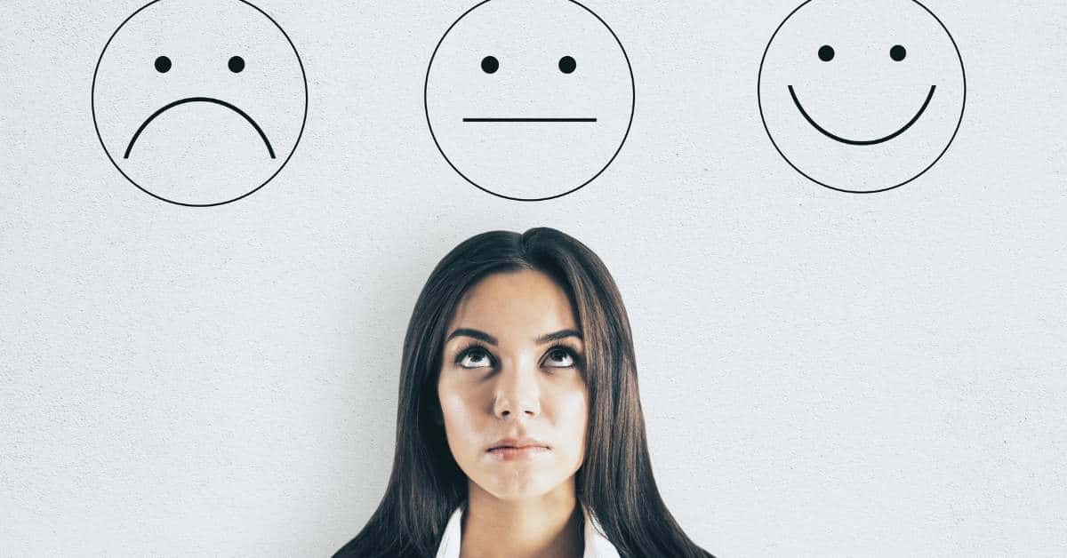 A frowny face, straight face, and smiley face with a woman standing under the straight face and looking up with an unhappy look