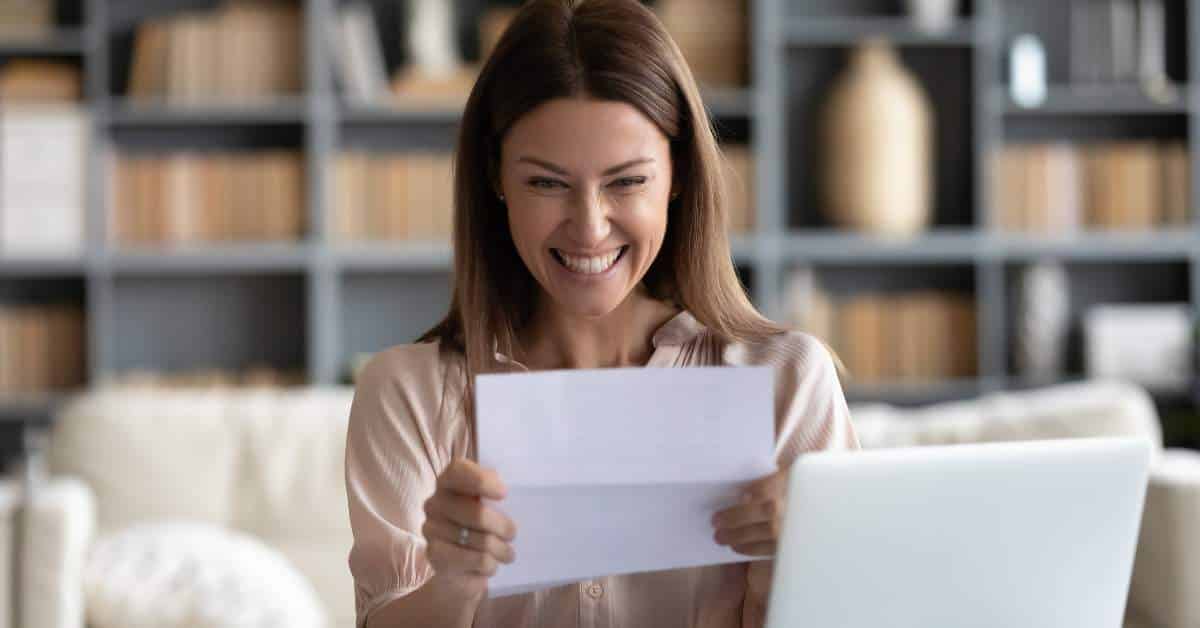 Young woman excitedly reading a scholarship offer