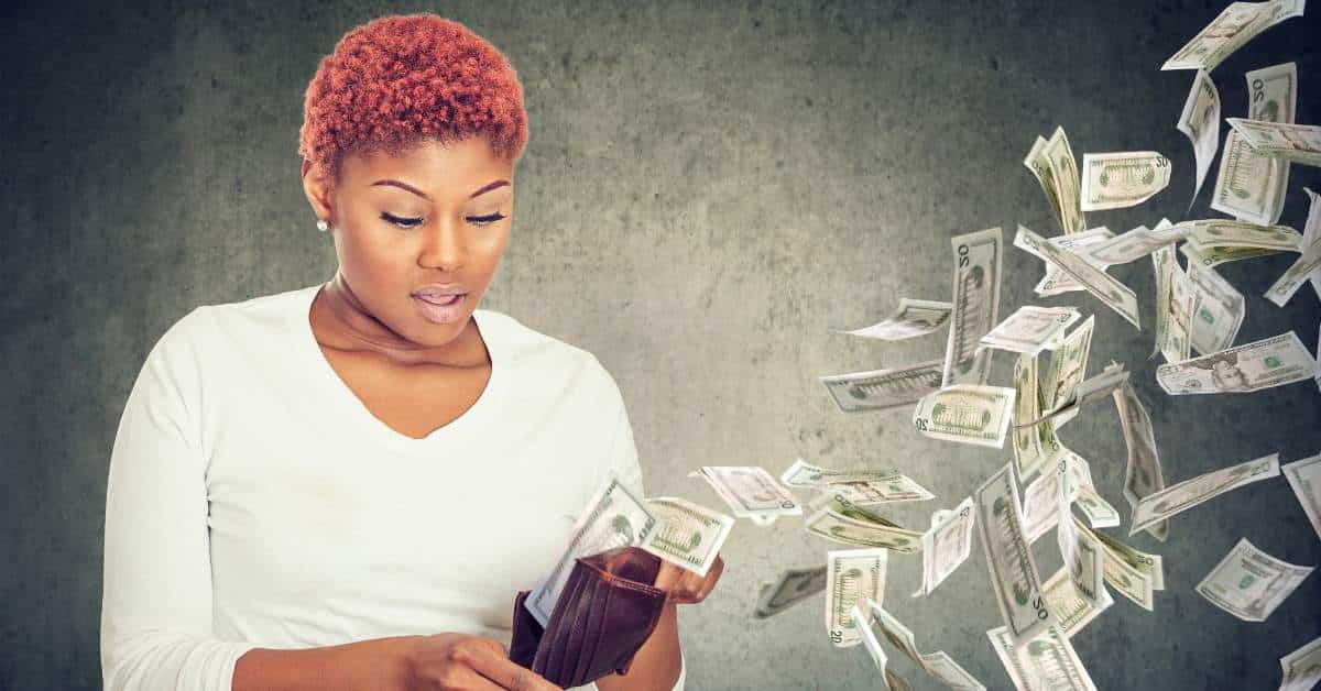 Woman opening her wallet and money is flying away